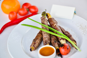 kebab lulya on asparagus in a plate with sauce