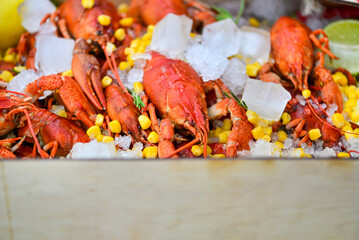 box of boiled crayfish with ice and boiled corn and salad
