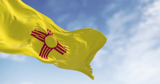 New Mexico state flag waving with red Zia sun symbol on yellow background