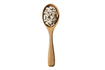 Wooden spoon filled with hulled sunflower seeds isolated on transparent background. Shelled sunflower seeds resting in a wooden spoon isolated on white background.