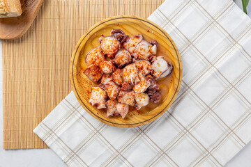 Galician octopus tapa pulpo a la gallega serving on wooden plate