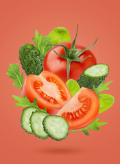 Vegetable salad ingredients - red tomatoes, green cucumbers, spinach, arugula -  fly as art...