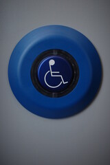 Blue button with a wheelchair symbol on it