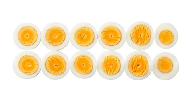 Hard boiled eggs are cut in half and arranged in two rows against a dark . - high quality Hard boiled eggs are cut in half and arranged in two rows ag