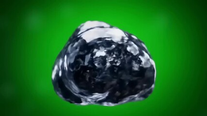 A glistening dark stone against a vibrant green backdrop