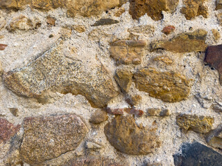 Rough stone wall displaying a textured pattern, ideal for backgrounds