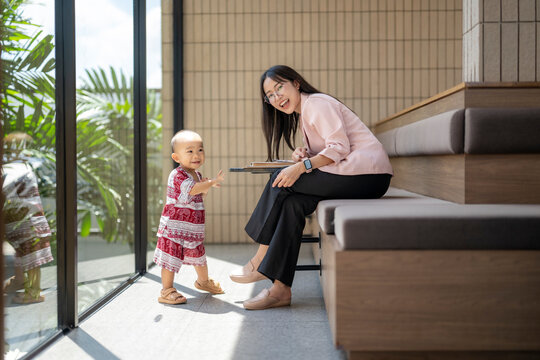 Businesswoman working remotely while taking care of her baby