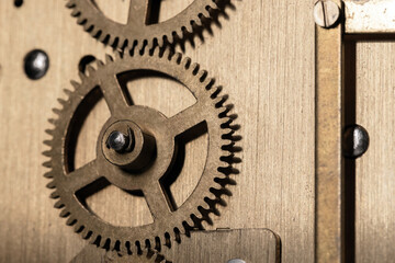 A detailed close-up of bronze gears meshing inside a clock mechanism