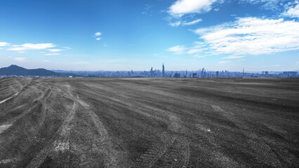 Vast open land with city skyline in the distance under a clear blue sky