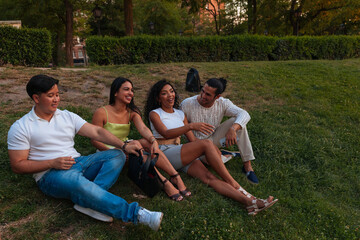Fototapeta premium Group Of Friends Relaxing In A Park, Laughing And Chatting On A Sunny Day