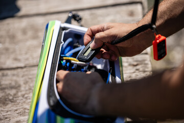 Technician checking battery status of electric surfboard with multimeter