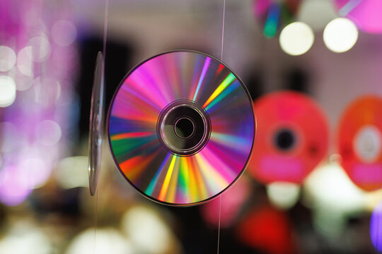 Compact disc suspended with colorful blurred background - Powered by Adobe