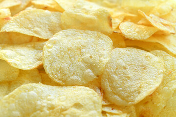 Potato chips or crisps texture background. Crunchy fried potato slices.