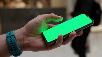 Green screen phone held by hand with smart watch for app promo or social media content creation - Powered by Adobe
