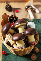 Mushroom and fir-shaped cookies made from shortcrust pastry and ceramic mushrooms on a wooden background.