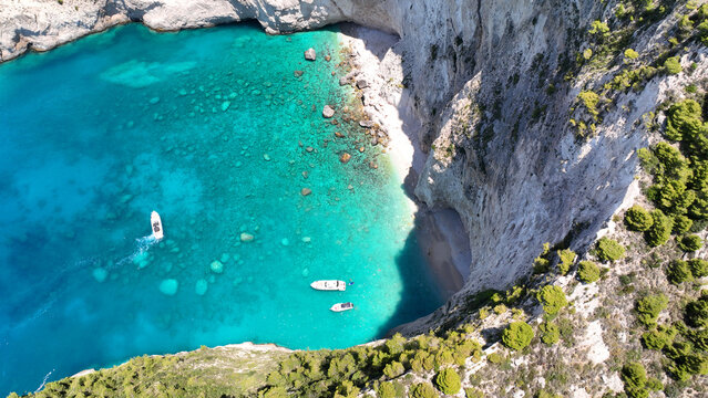 Aerial drone photo of famous steep rocky white cliffs creating beautiful coves and turquiose sea caves of Kampi visited by small boats and yachts in northern part of Zakinthos island, Ionian, Greece