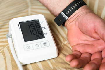 Measuring blood pressure with an automatic blood pressure monitor at home.