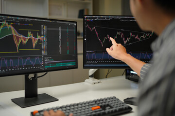 Busy business man trader broker analyst investor analyzing stock exchange trade crypto market using pc computer digital data investing finances in stock market working in dark office.