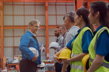 A group of engineers and staff members are discussing their work while working in a metal sheet and...