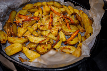 Roasted Potato Pieces with Cheese and Carrots on Baking Tray