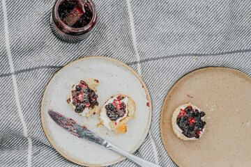 A plate of pastries with a jar of jam on a table