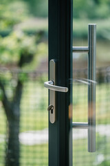 Modern front door with transparent glass and sleek handle in residential setting