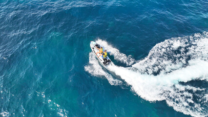 Aerial drone photo of jet ski watercraft performing extreme manoeuvres showing off in high speed operated by stuntman in deep blue sea © aerial-drone