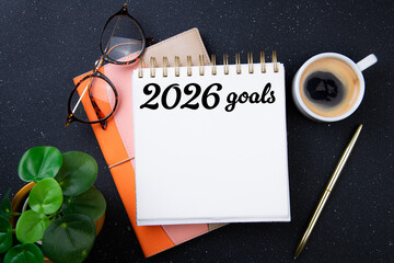 New year goals 2026 on desk. 2026 resolutions list with notebook, plant on black table. Resolutions, plan, goals, action, checklist, idea concept. New Year 2026 resolutions, copy space