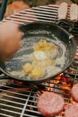 A person is cooking food on a grill, and the food is covered in butter