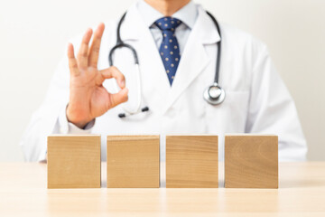 OKサインをする医者と無地のブロック