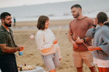 A group of people are standing on a beach, holding sticks