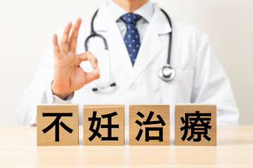 「不妊治療」と書かれたブロックとOKサインをする医師