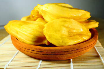 Fresh yellow jackfruit bulbs in a wooden bowl