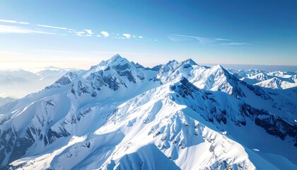 Snow-covered mountain range under a bright blue sky, showcasing majestic natural beauty and vast landscapes ideal for adventure and travel