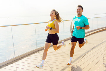 Jogging couple enjoy exercise along coastal pathway with scenic water views and a healthy lifestyle atmosphere