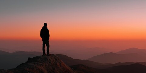 Obraz premium Silhouette of caucasian male adult gazing at mountain sunset horizon