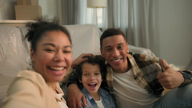 Smiling African American funny family selfie photo grimacing joy having fun at home parents lovely child kid boy son fooling around together take picture video call conference vlog phone camera view