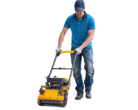Construction worker operating a gasoline-powered asphalt compactor in a construction site environment under bright lighting