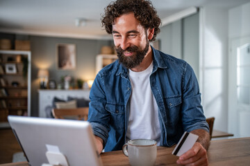 Man shopping online using tablet with credit card