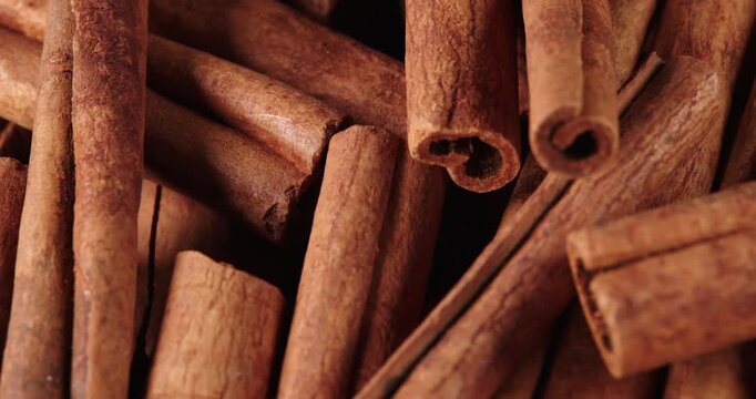 Cinnamon sticks rotate as a background. Fragrant cinnamon close-up. Spices with cinnamon. Food cooking video concept.