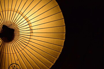 夜に照らされた黄色い和傘のクローズアップ、コピー用のスペースあり