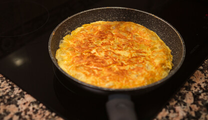 Potatoes, onion and eggs frying on pan. Spanish cuisine. Cooking delicious spanish omelette at home.