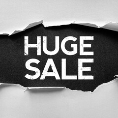 Torn paper revealing the bold distressed text HUGE SALE on a dark textured background, conveying...
