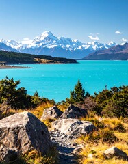 Obraz premium A stunning, vibrant landscape showcases a lake's turquoise waters against snow-capped mountains under a clear blue sky