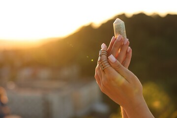 Woman meditating with crystal to heal or restore her aura outdoors, closeup. Space for text