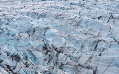 Frozen blue ice waves of a glacier
