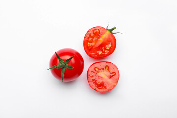Whole and cut red tomatoes on white background, flat lay