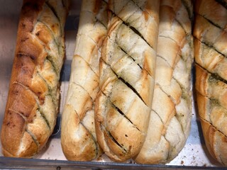 French baguettes with herbs and garlic in the bakery. Top view