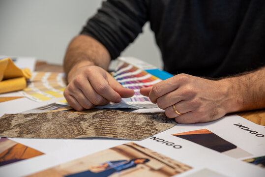Creative designer examines fabric samples while planning a new fashion collection in a studio