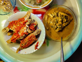close up of a bowl of fried banana fish or fusilier fish with chili sauce